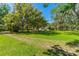 Lush green lawn with mature trees draped with Spanish moss across the property grounds at 191 Howes St, Oak Hill, FL 32759