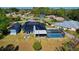 Lush aerial view of a home showcasing its metal roof, pool, fire pit, and spacious green yard at 1948 Spruce Creek Lndg, Port Orange, FL 32128