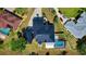 An overhead view of the home showcasing a well-manicured lawn, long driveway, and a screened-in pool at 1948 Spruce Creek Lndg, Port Orange, FL 32128