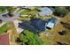 Wide aerial view of this home featuring a metal roof, solar panels, screened-in pool and stone fire pit at 1948 Spruce Creek Lndg, Port Orange, FL 32128