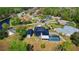 Aerial view of the house featuring solar panels, manicured landscaping, and a screened-in pool at 1948 Spruce Creek Lndg, Port Orange, FL 32128