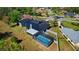 Picturesque aerial view of a home with a screened-in pool, solar panels, metal roof and large lot at 1948 Spruce Creek Lndg, Port Orange, FL 32128