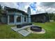 Wide backyard view showing the home's fire pit area, screened-in patio, and manicured lawn at 1948 Spruce Creek Lndg, Port Orange, FL 32128