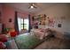 This bedroom features hardwood floors, a ceiling fan, and a window overlooking the backyard at 1948 Spruce Creek Lndg, Port Orange, FL 32128