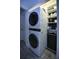 Convenient laundry area with stacked washer/dryer unit and built in storage shelving for organization at 1948 Spruce Creek Lndg, Port Orange, FL 32128