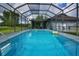 This pool features a screened-in enclosure, blue water, and pool toys at 1948 Spruce Creek Lndg, Port Orange, FL 32128
