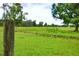 Back property line with a barbed wire fence and open green space at 1948 Spruce Creek Lndg, Port Orange, FL 32128