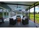 Inviting screened porch with ceiling fan, wicker furniture, and seamless access to the pristine swimming pool at 1948 Spruce Creek Lndg, Port Orange, FL 32128