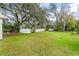 Sprawling backyard featuring a well-maintained lawn, privacy fence, mature trees, and an outdoor shed at 20 Warwick Ave, Ormond Beach, FL 32174