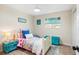 Cozy bedroom with light-colored walls and floor with teal painted furnishings and bright bedding at 20 Warwick Ave, Ormond Beach, FL 32174