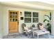 Inviting front porch with chairs and wood door at 20 Warwick Ave, Ormond Beach, FL 32174