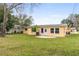 Expansive backyard featuring green grass, a patio and mature trees at 2211 Brian Ave, South Daytona, FL 32119