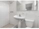 A bright, all-white bathroom features tiled walls, pedestal sink, and updated fixtures at 2211 Brian Ave, South Daytona, FL 32119