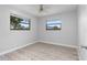 A bright bedroom with wood-look flooring features two windows bringing in natural light at 2211 Brian Ave, South Daytona, FL 32119
