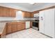 Kitchen with wood cabinets, white appliances, and tile flooring at 2211 Brian Ave, South Daytona, FL 32119