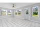 Living room with tile flooring, ceiling fan, many windows, and glass door at 2211 Brian Ave, South Daytona, FL 32119