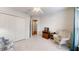 Cozy bedroom features a rocking chair, neutral carpet, and spacious closet for ample storage at 2307 Needle Palm Dr, Edgewater, FL 32141