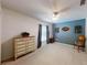 Bright bedroom showcasing blue accent wall, ceiling fan and a decorative dresser for storage at 2307 Needle Palm Dr, Edgewater, FL 32141