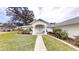 Beautiful single-story home with mature landscaping, a walkway, and a charming front porch area at 2307 Needle Palm Dr, Edgewater, FL 32141