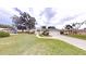 Inviting single-story home featuring a lush green lawn and a long driveway leading to the attached garage at 2307 Needle Palm Dr, Edgewater, FL 32141