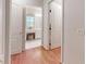 Hallway view into bathroom with vanity, stool, and bright natural light from a window at 2307 Needle Palm Dr, Edgewater, FL 32141