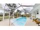 Enclosed pool area featuring a sparkling pool, white tile flooring and a seating area at 2307 Needle Palm Dr, Edgewater, FL 32141