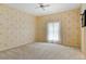 Spacious bedroom with neutral carpet, ceiling fan, and natural light from a window at 2333 Southern Pines Pl, Deland, FL 32724