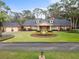 Charming home featuring a circular driveway, mature landscaping, and traditional architectural details at 2333 Southern Pines Pl, Deland, FL 32724