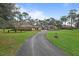 Inviting brick home with well-manicured lawn, mature trees, and a winding driveway leading to the entrance at 2333 Southern Pines Pl, Deland, FL 32724