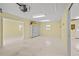 Large garage interior with ample shelving, overhead lighting, and access to the outdoors at 2333 Southern Pines Pl, Deland, FL 32724