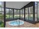 Inviting hot tub area with brick patio, glass walls, and serene views of the backyard and surrounding trees at 2333 Southern Pines Pl, Deland, FL 32724
