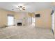 Spacious living room featuring a classic fireplace, ceiling fan, and a door leading to the exterior of the home at 2333 Southern Pines Pl, Deland, FL 32724