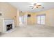 Large living room with a fireplace, ceiling fan, and exterior doors creating a comfortable living space at 2333 Southern Pines Pl, Deland, FL 32724