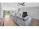 Bright and airy living room with wood floors, a gray sectional sofa, and an open view into the kitchen at 2347 Cr 546A, Bushnell, FL 33513