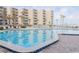 Large, inviting pool with plenty of lounge seating at beachfront condo community with beach access and palm trees at 2401 S Atlantic Ave # A604, New Smyrna Beach, FL 32169