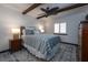 Charming main bedroom with wood beam ceilings, a ceiling fan, and comfortable furnishings at 2401 S Atlantic Ave # D301, New Smyrna Beach, FL 32169