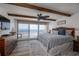 Primary bedroom featuring an ocean view, wood beams, and ceiling fan at 2401 S Atlantic Ave # D301, New Smyrna Beach, FL 32169