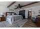 This bright main bedroom boasts wood beams, an ensuite bathroom, and stylish coastal decor at 2401 S Atlantic Ave # D301, New Smyrna Beach, FL 32169