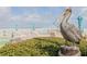 Pelican statue overlooking outdoor lounge area with tables, chairs, and umbrellas at 2401 S Atlantic Ave # D301, New Smyrna Beach, FL 32169