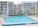 Inviting community pool with crystal-clear water and lounge chairs provides relaxation by the beautiful condominium complex at 2401 S Atlantic Ave # D301, New Smyrna Beach, FL 32169