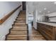 Elegant staircase with wooden steps, adjacent to the modern kitchen and living area at 2401 S Atlantic Ave # D301, New Smyrna Beach, FL 32169