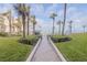 Landscaped walkway with lush greenery leads to a beautiful community pool and beach at 2401 S Atlantic Ave # D301, New Smyrna Beach, FL 32169