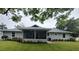 Well-maintained backyard with lush green grass, beautiful landscaping, a screened-in patio, and a charming fountain at 2409 Victory Palm Dr, Edgewater, FL 32141