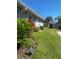 Backyard with lush lawn, mature landscaping, and a detached shed in the background at 2409 Victory Palm Dr, Edgewater, FL 32141