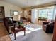 Comfortable living room with neutral walls, cozy seating, and light streaming through large windows at 2409 Victory Palm Dr, Edgewater, FL 32141