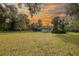 Expansive backyard with lush greenery, mature trees, and a cozy home with a screened-in porch at 2576 Shilo Glynn Ln, New Smyrna Beach, FL 32168