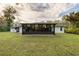 Lush backyard featuring the house with its large windows and screened-in porch, perfect for enjoying the outdoors at 2576 Shilo Glynn Ln, New Smyrna Beach, FL 32168
