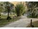 Exterior view of the property featuring a long driveway leading to multiple buildings amid lush landscaping at 2576 Shilo Glynn Ln, New Smyrna Beach, FL 32168