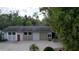 A two-car garage featuring white and tan siding, a red door, and a concrete driveway at 2576 Shilo Glynn Ln, New Smyrna Beach, FL 32168