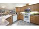 Well-equipped kitchen with wood cabinets, white appliances, and a functional layout ideal for cooking and entertaining at 2576 Shilo Glynn Ln, New Smyrna Beach, FL 32168